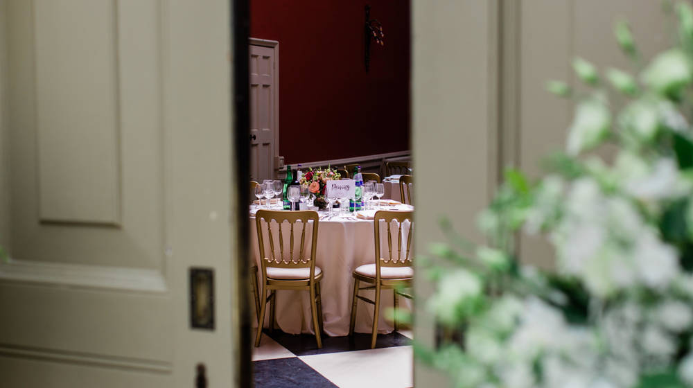 Wedding Breakfast tables set, glimpsed through open door